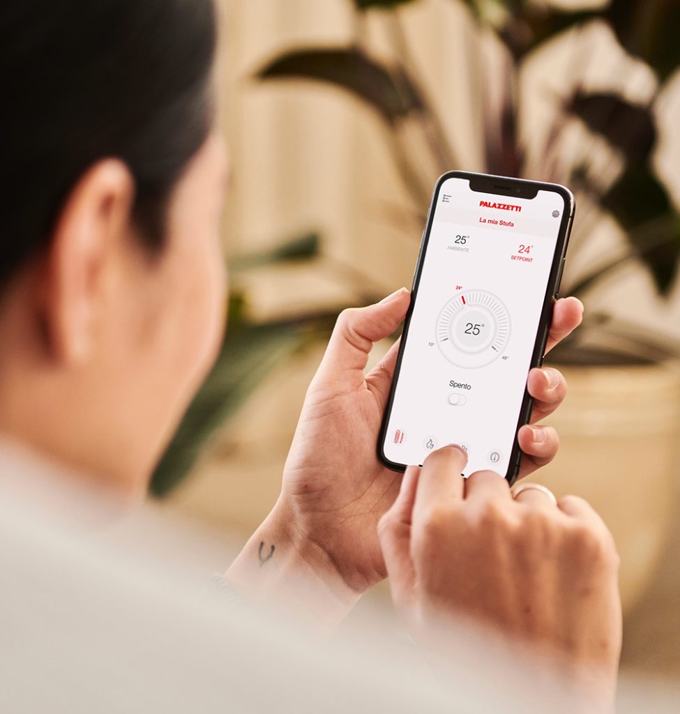 Donna che tiene in mano un telefono che mostra l'app Palazzetti